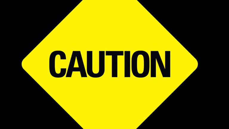 A yellow diamond-shaped sign with the word CAUTION in bold black letters on a black background.