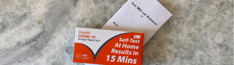 A COVID-19 at-home rapid test kit and a white envelope labeled Test, Billing and Treatment are placed on a gray marble surface.