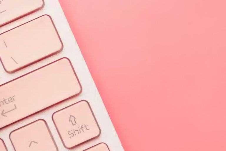 A combination padlock resting on a pink computer keyboard, symbolizing cybersecurity or data protection, with a bright pink background.