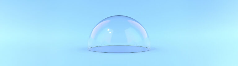 A transparent glass dome sits on a smooth, light blue surface against a matching blue background, with soft reflections and subtle hints of pink and purple on the dome.
