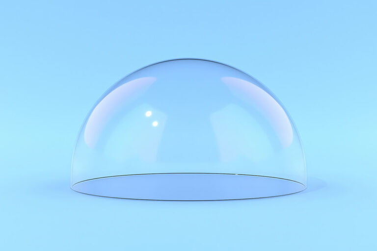 A transparent glass dome sits on a smooth, light blue surface against a matching blue background, with soft reflections and subtle hints of pink and purple on the dome.
